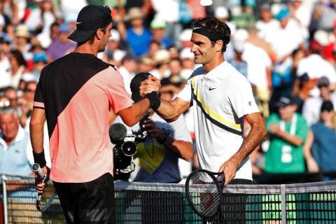 Thanasi Kokkinakis shaking hands with Swiss star Roger Federer.